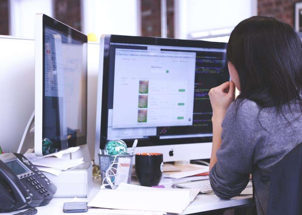 Working at a desk with two monitors